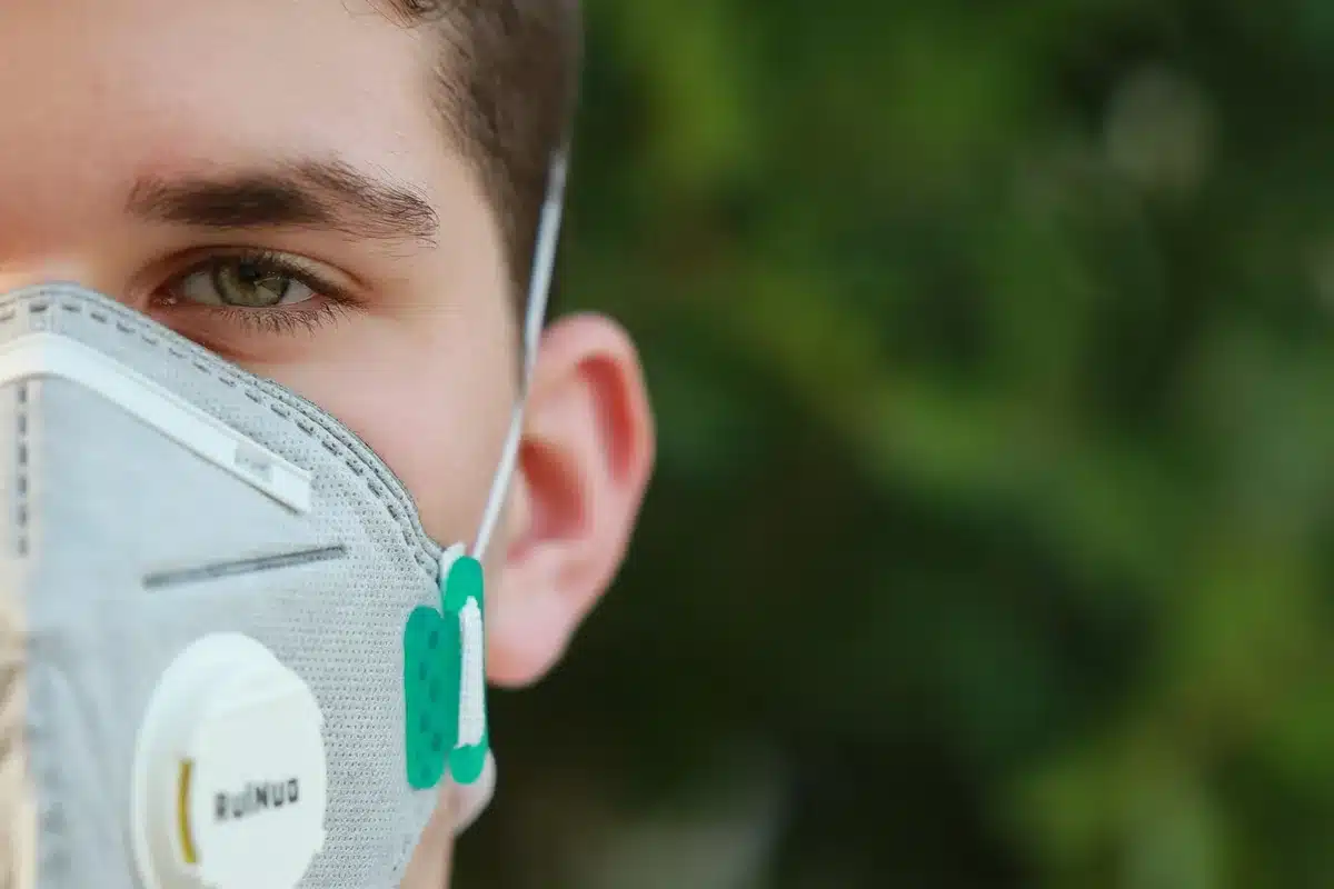 Travailleur portant un masque respiratoire certifié et des lunettes de sécurité sur un chantier