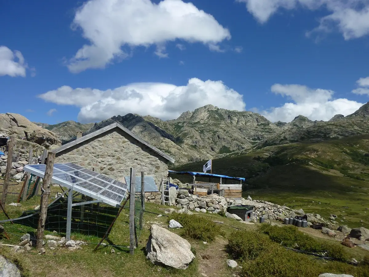 Panneaux solaires et onduleur reliés à une maison, vue en plein jour