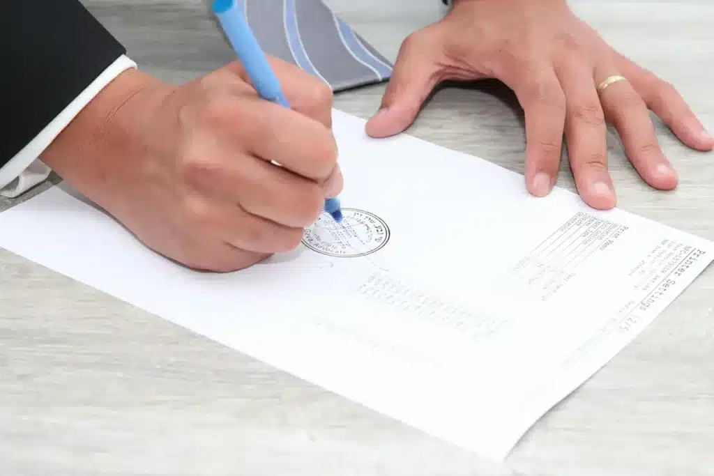 Mains anonymes tenant des documents financiers et une calculatrice sur une table
