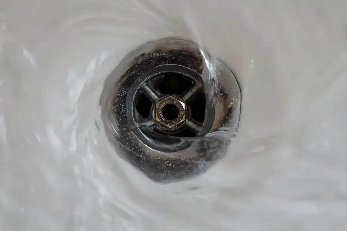 Personne vidangeant un ballon d'eau chaude depuis un robinet de vidange