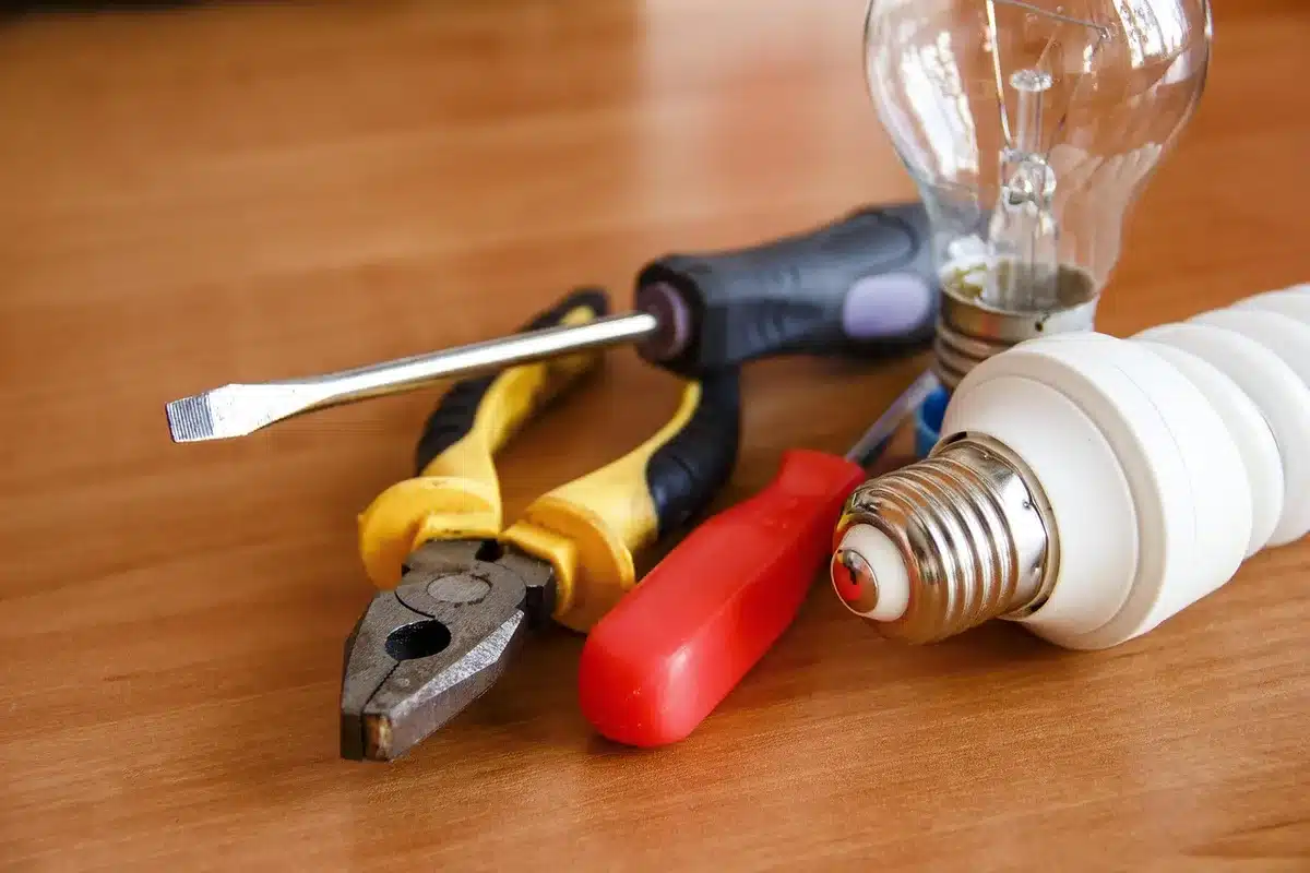 Artisan inspectant un chauffe-eau électrique avec outils