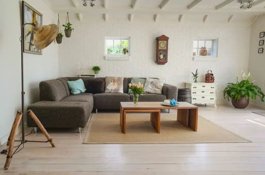 Mains ajustant un thermostat mural dans un salon lumineux en journée