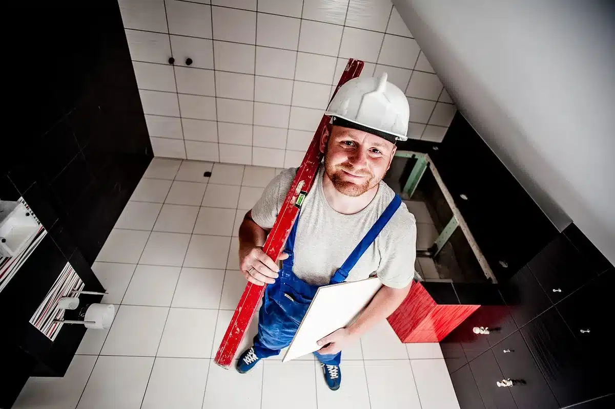 Allée et portail métallique partiellement ouvert avec outils de chantier sur une table, jour