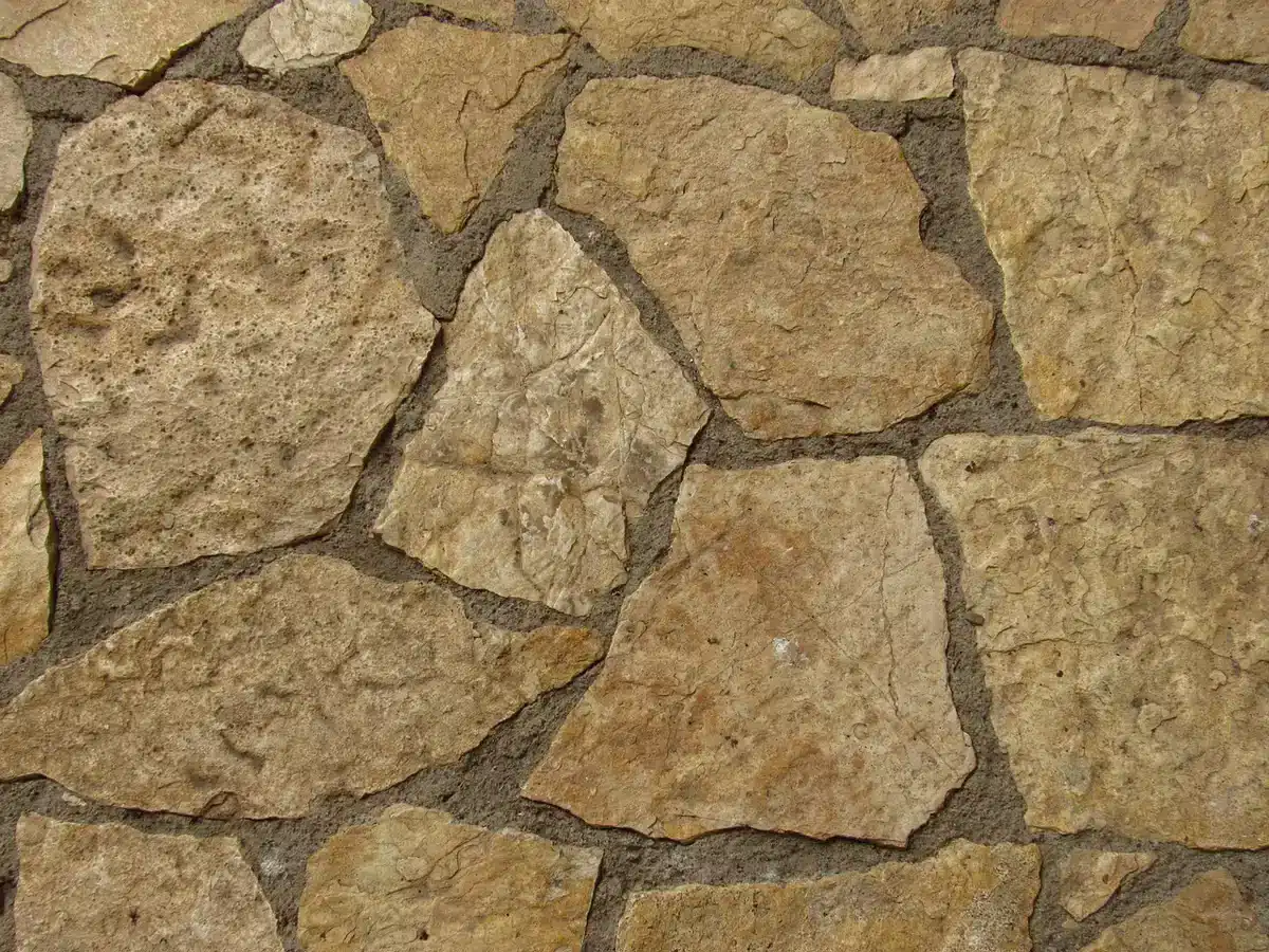 Main gantée utilisant une taloche pour remplir un joint en diagonale