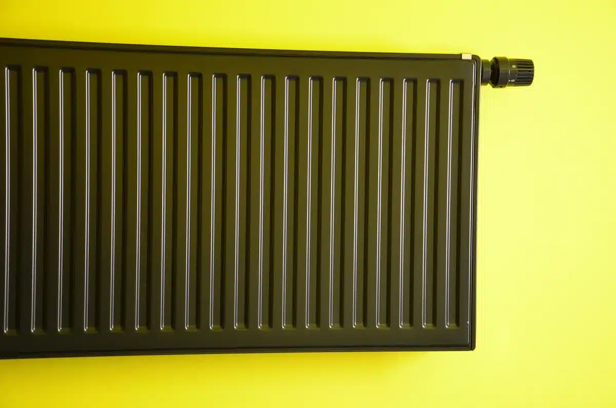 Personne tenant une sonde de température près d'un radiateur à eau